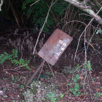 This sign was near a stream.  Any guess as to what it once said?